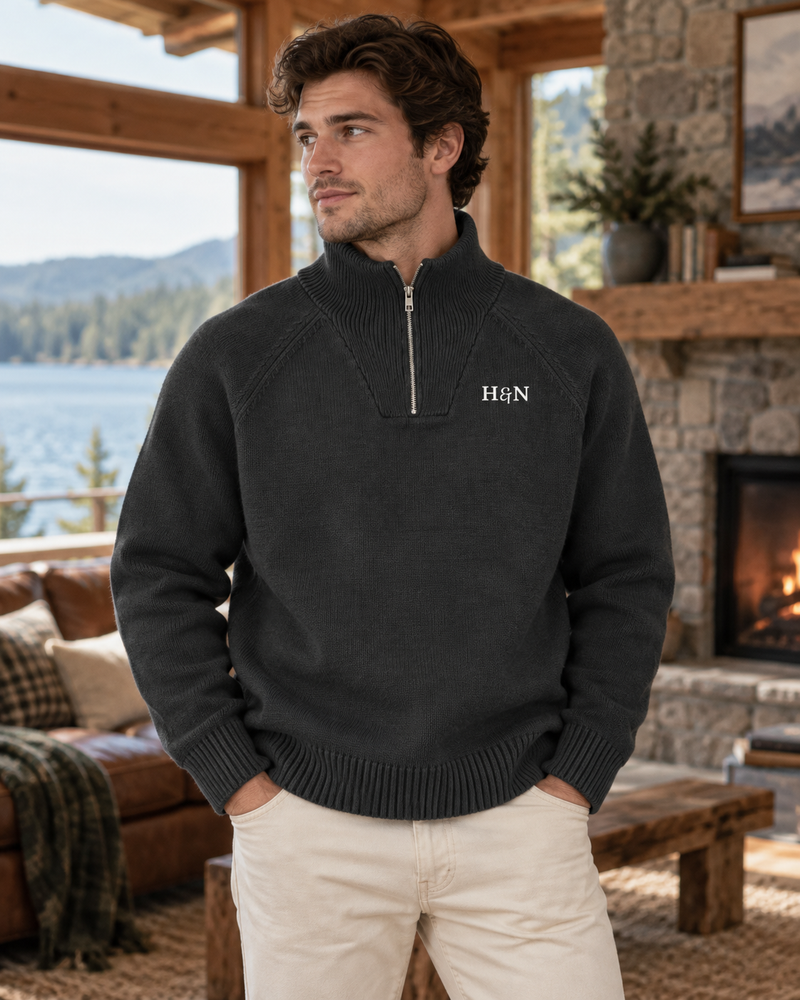 Hearth Quarter-Zip in dark grey on a man by the lake window, H&N monogram in cream at the left chest