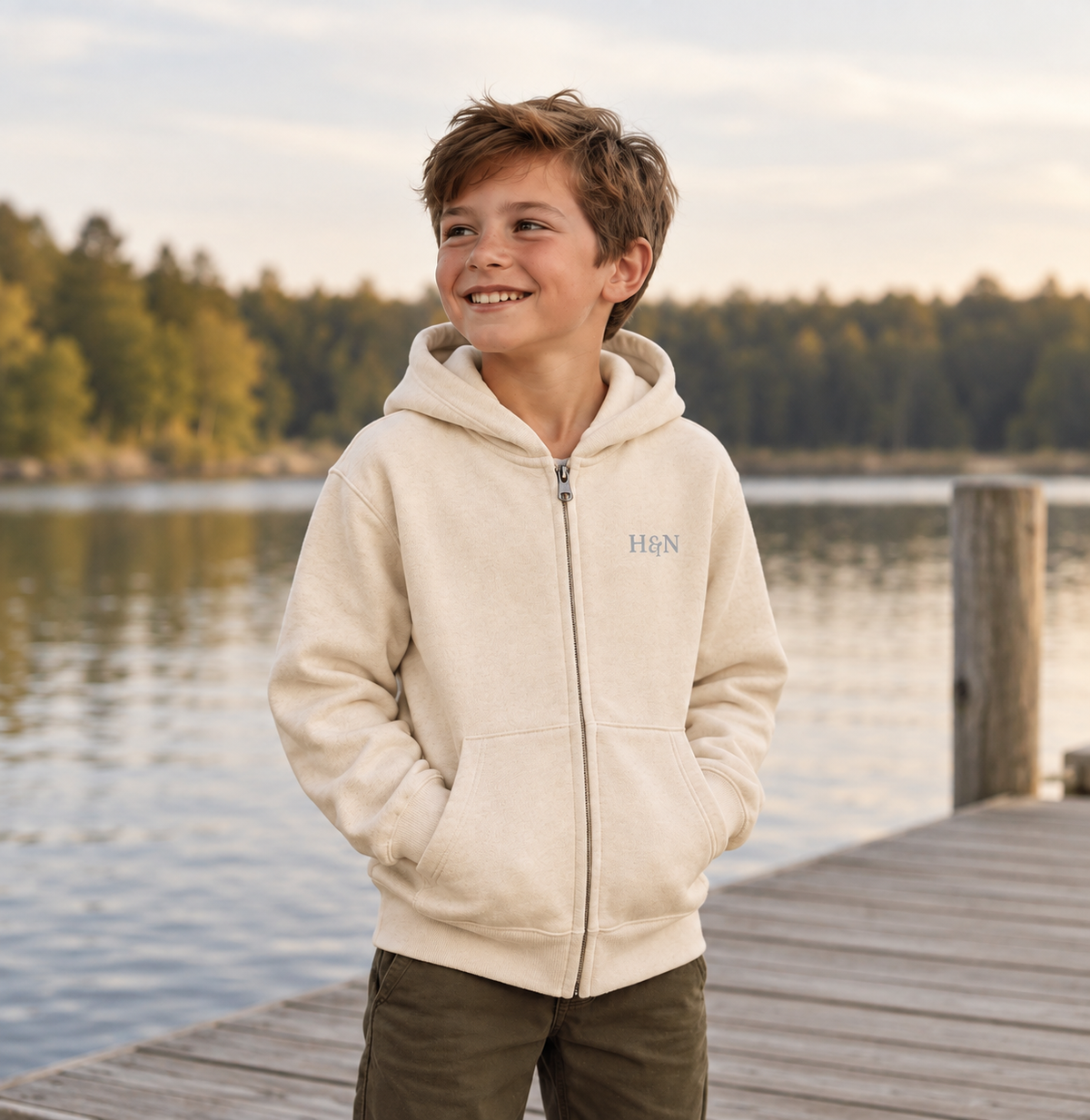 Full-Zip Hoodie in dust, worn on a dock by the lake.