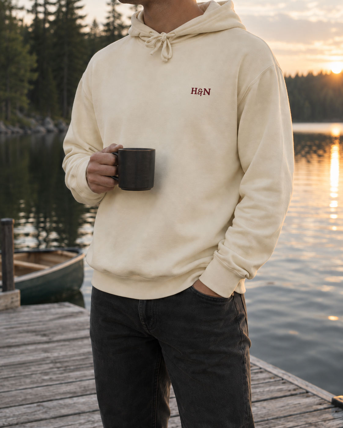 Lounge Hoodie in ivory, worn on the dock at sunset with a mug.