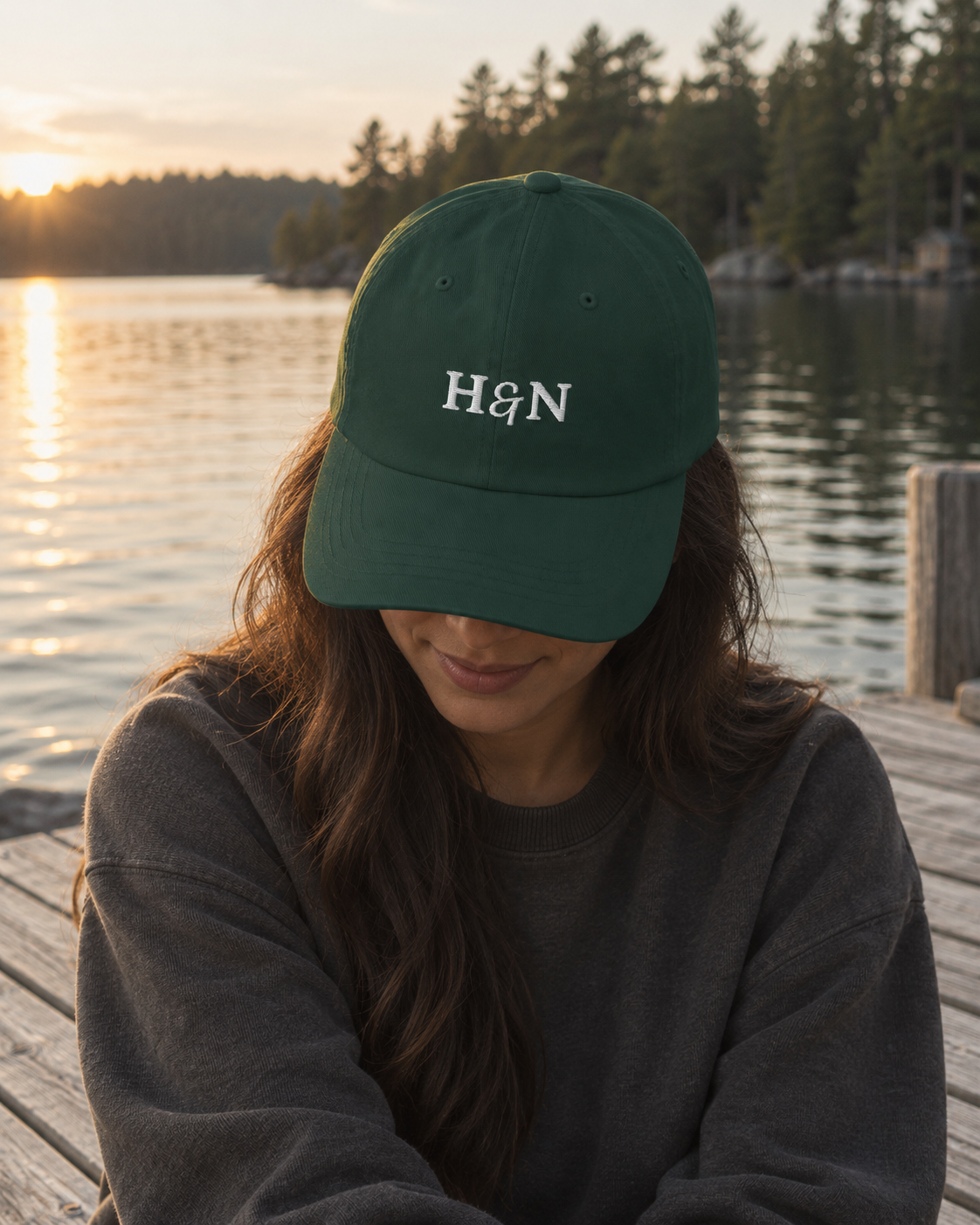 Monogram Cap in spruce, worn by the water.